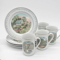 Stacked plates and four mugs showing pattern and gold trim