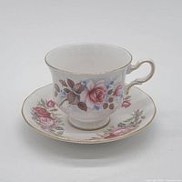 Teacup on saucer showing floral design and gold trim
