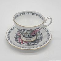 Teacup on saucer showing floral pattern and gold trim
