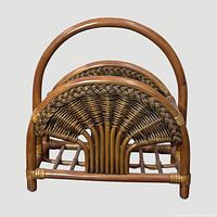 Front view showing arched handle, woven wicker panel, slatted base