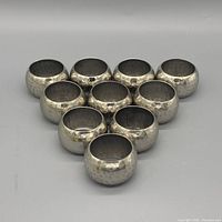 All ten hammered silver-plated napkin rings arranged