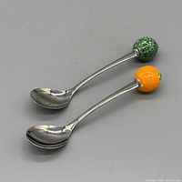 Top view of both teaspoons showing ceramic fruit accents