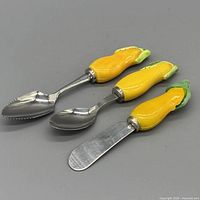 Three utensils side by side showing stainless steel ends and yellow ceramic handles