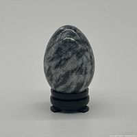 Front view of polished gray/black stone egg