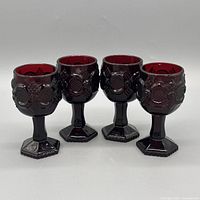 Four ruby glass goblets front view