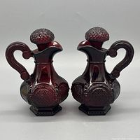 Front view of both ruby red cruets with stoppers