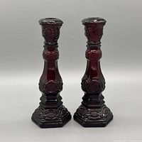 Full front view of the two ruby red glass candlesticks
