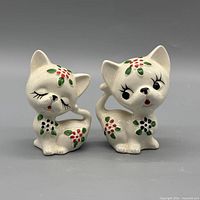 Front view of both cat shakers showing painted details