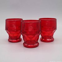 Front view of three ruby red honeycomb tumblers