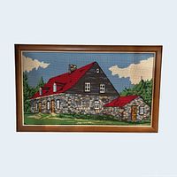 Front view of framed needlepoint showing entire house landscape
