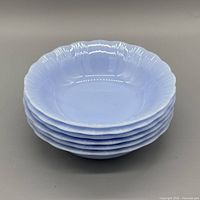 Stack of six Delphite blue bowls showing scalloped rims