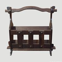 Front view of dark brown wood magazine rack showing slatted design