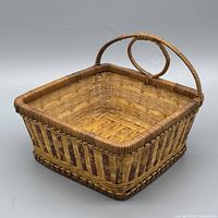 Overall view of square wicker rattan basket showing handle and pattern