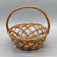 Front view of round open-weave wicker basket with handle