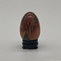 Front view of wood and resin floral egg on stand