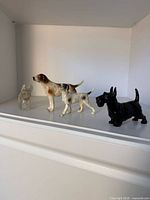 Group shot of four dog figurines on shelf