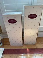Two Ashton-Drake Galleries doll boxes standing upright