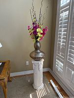 Full view of ceramic plinth, glass vase and faux flowers