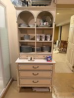 Full frontal view of cream wood hutch with open shelves and drawers
