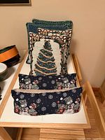 All six holiday pillows: three large tapestry pillows stacked, two snowman lumbar pillows in front