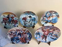 Group of five hockey-themed collector plates on easels