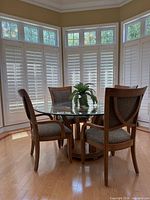 Full view of round glass dining table with four chairs