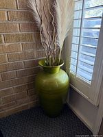 Full view of green floor vase with pampas grass in corner