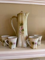Front view of teapot with four matching teacups