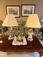 Two Capodimonte lamps and two figurines displayed on coffee table