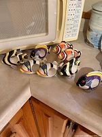 Eight ceramic fish napkin rings in assorted colors