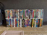 Shelf with about 45 Disney clamshell VHS movies