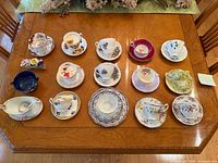 Full tabletop view showing all teacup/saucer sets and extra pieces