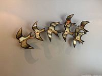 Front view of entire brass bird wall sculpture