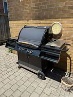 Full view of closed BBQ grill showing overall condition and cart structure