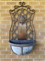 Front view of wall planter showing lattice back, sun medallion, bowl