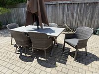 full view of table with six chairs and umbrella