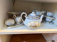 Shelf with Silver Birch teapot, creamer and multiple cups, saucers and plates showing overall lot contents