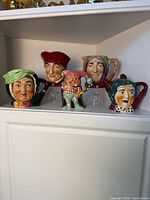 Five character ceramic pieces on shelf