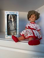 Both dolls, boxed and loose, displayed on shelf