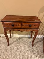 Front view of wooden hall table showing two drawers, carved details and cabriole legs