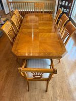 Top view of dining table showing veneer pattern and eight chairs