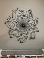 Front view of entire metal starburst wall art on wall