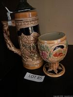 Front view of ceramic beer stein and pedestal goblet