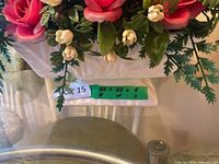 Close-up of planter base with artificial flowers and dimension label