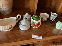Front view of five ceramic items lined on shelf