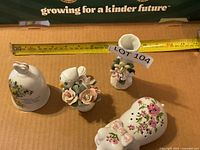 Overview of four porcelain pieces with tape for scale