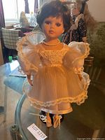 Front view of porcelain ballerina doll on stand showing full outfit and shoes