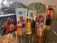 Front view of all seven dolls in their cases
