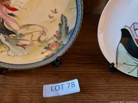 Front view of Chinese maiden decorative plate on stand with part of Japanese plate visible