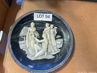 Front view of decorative plate with cameo figures and Greek key border